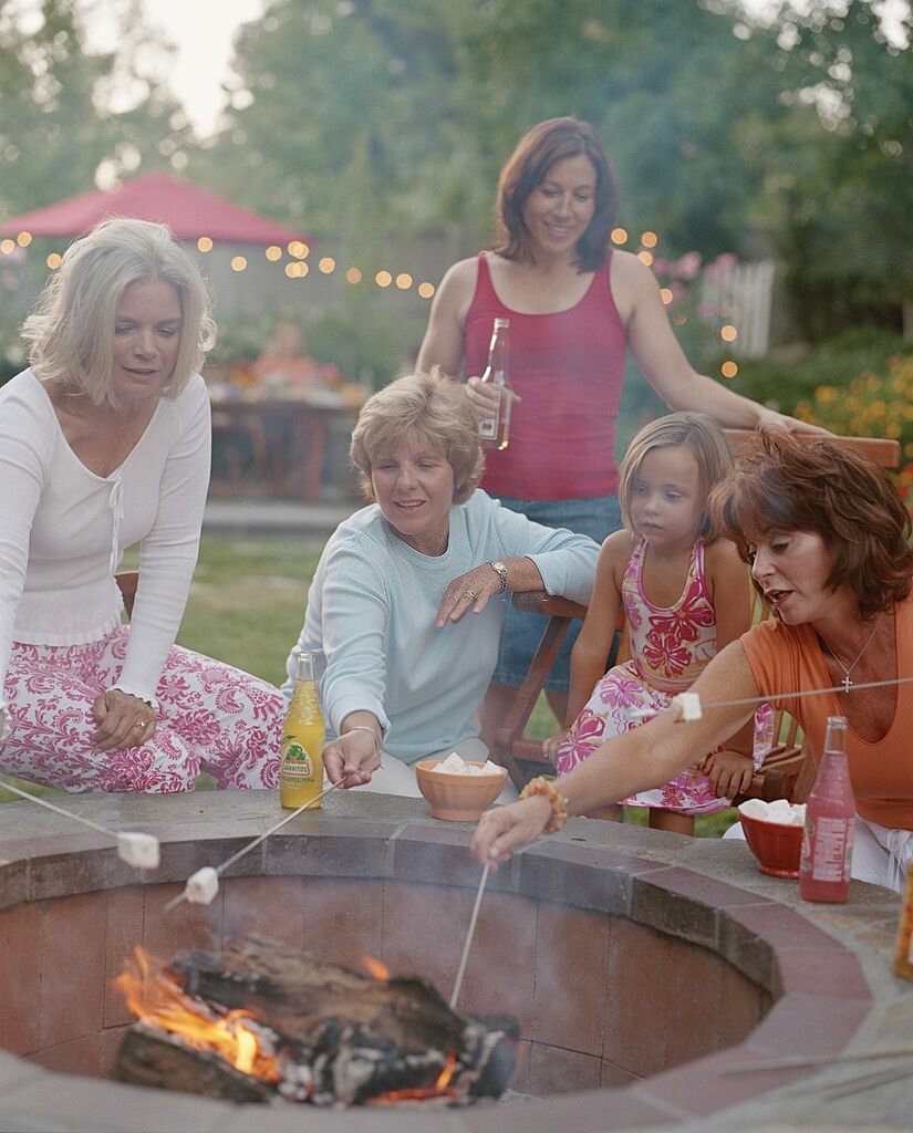 Women roasting marshmallows on a fire pit