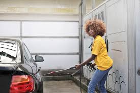 Afro-American woman cleaning a car
