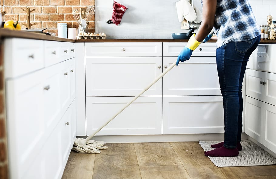 Housekeeping lady moping the kitchen floor