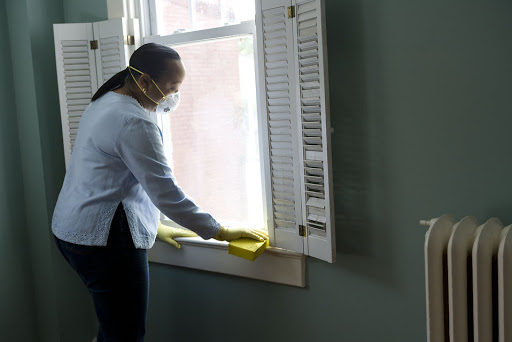 Housekeeping lady cleaning the windows with a sponge